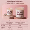 A product information graphic for the Hand Poured 'Do Not Disturb' scented candle. The top half shows two sizes of the frosted glass candle on pink blocks against a pink background.