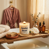 Lit Sunday Reset beeswax candle on wooden bath tray with towels and flower