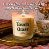 Lit Touch Grass beeswax candle on gold tray with teacup