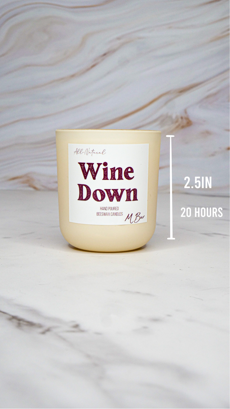 Cream Wine Down beeswax candle with size label on marble