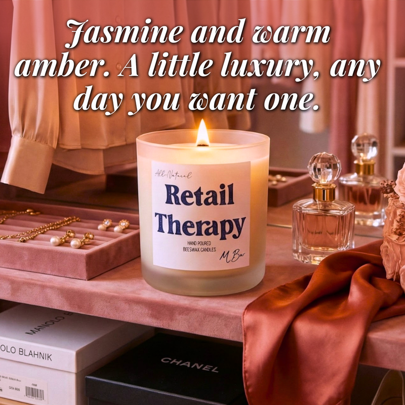 Lit Retail Therapy beeswax candle on vanity with perfume and jewelry