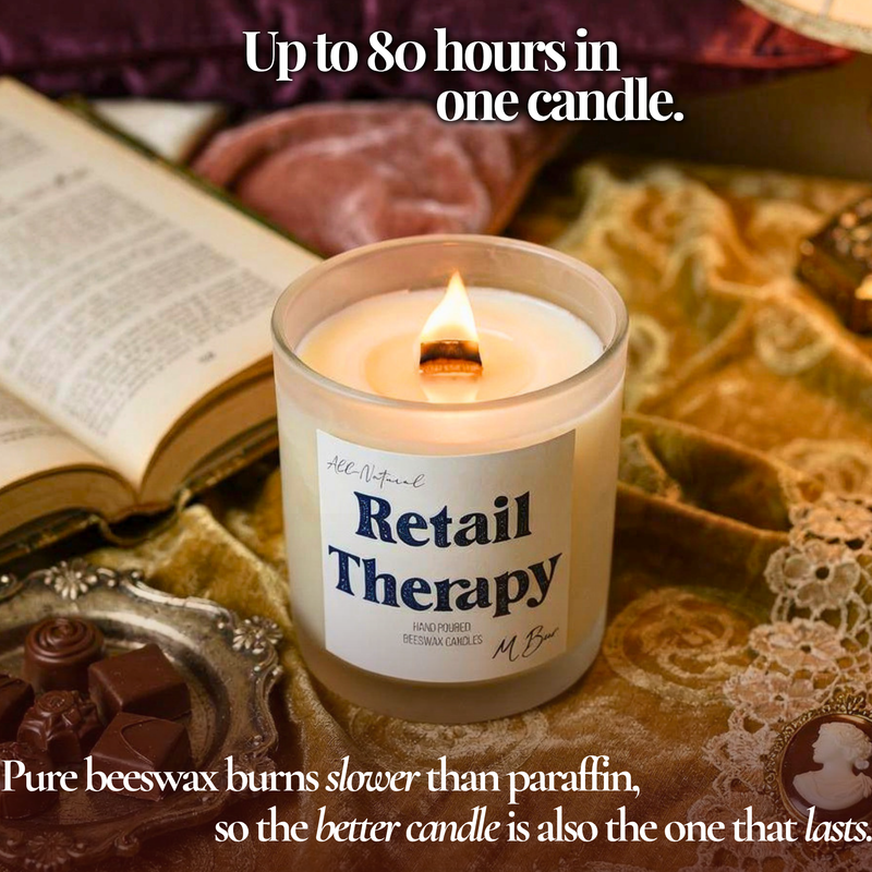 Lit Retail Therapy beeswax candle with wooden wick on gold velvet